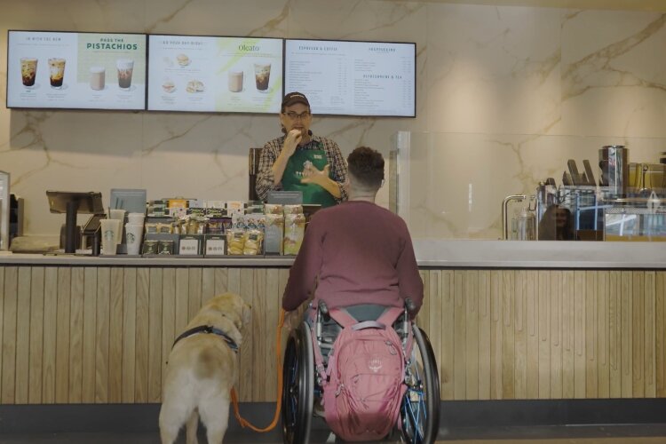 The manager at the new accessible Starbucks store uses sign language to communicate with a customer. 