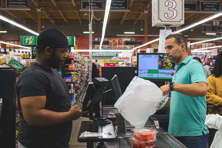 Vincent Nona checks out a customer at Parkway Foods. 