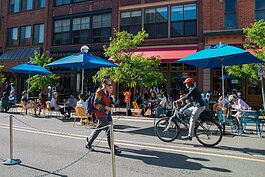 People walk and bike down Washington Street in Ann Arbor.