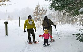 A family enjoys a winter walk at Hemlock Crossing.